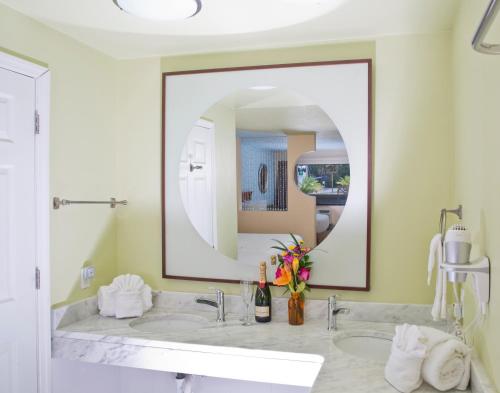 a bathroom with a sink and a large mirror at The Ponce St. Augustine Hotel in Saint Augustine