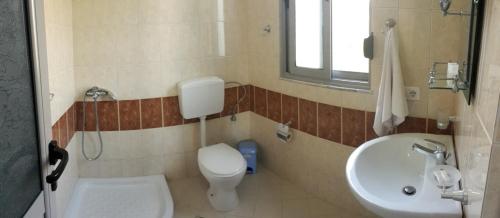 ein Badezimmer mit Toilette und Waschbecken in der Unterkunft Ilion Hotel in Dhërmi