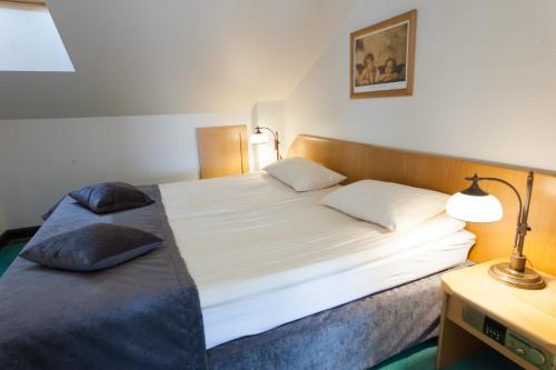 a bedroom with a large bed with two pillows on it at Piwnica Rycerska Kęty in Kęty
