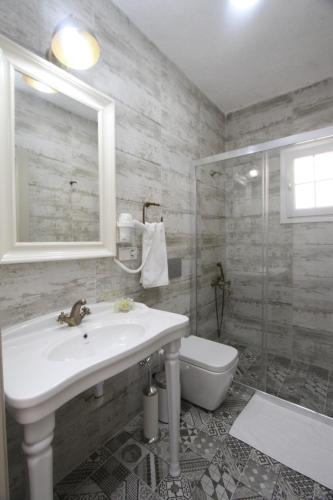 a bathroom with a sink and a shower and a toilet at Alya Mou Butik Hotel in Çeşme