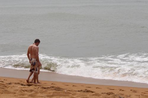 a man standing on the beach looking at the ocean at Anura Home Stay in Kalutara