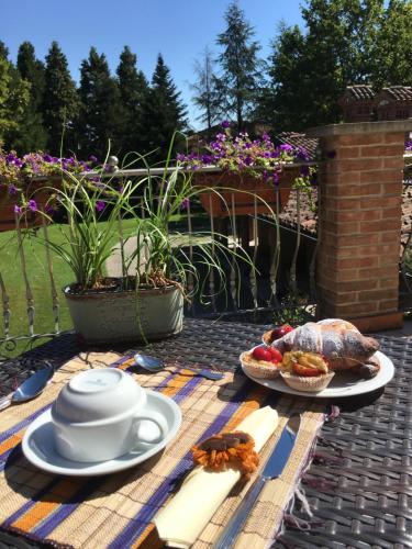 a table with a tea pot and a plate of food at B&B Villa Valchero in Carpaneto Piacentino
