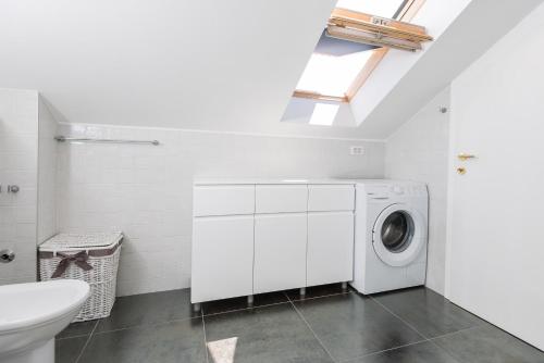 a white laundry room with a washer and dryer at Apartman Marica in Orebić