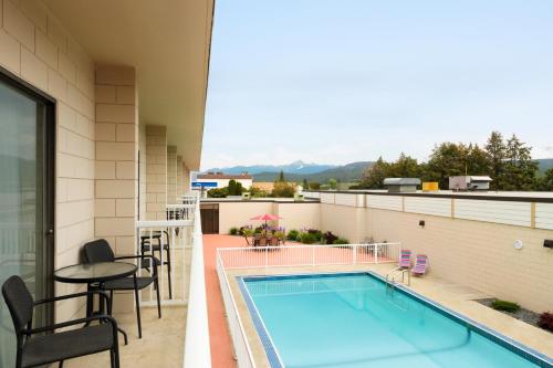 a swimming pool on a balcony with a table and chairs at Days Inn by Wyndham Cranbrook Conference Centre in Cranbrook