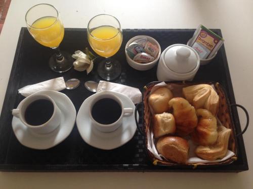 Complejo Ayenué & Spa في أوستند: صينية عليها كوبان من القهوة وسلة من المعجنات