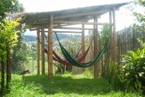 a hammock under a wooden structure in a garden at La Cigarra Casa de Huéspedes in Salento