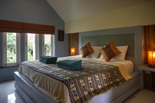 a bedroom with a bed with two green pillows on it at Hideaway Villa in Laem Set Beach