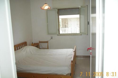 Habitación pequeña con cama y ventana en casa posto cantoro 1, en Marina di Pescoluse