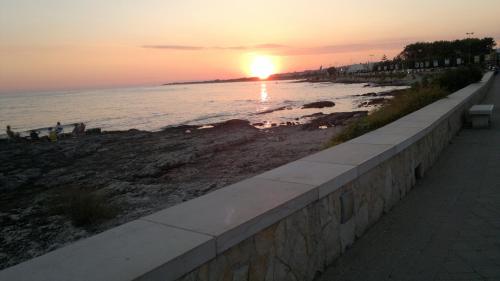 una puesta de sol en una playa con puesta de sol en casa posto cantoro 1, en Marina di Pescoluse
