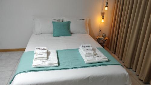 a white bed with towels on it in a room at Workspace.job in Portimão