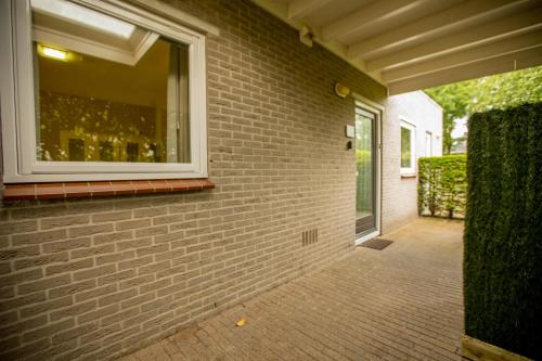 a brick wall with a window on the side of a house at Xenith Gastenverblijf in Apeldoorn