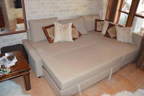 a couch with pillows on it in a living room at Czarina Cabin הבקתה הקיסרית והדירה הקיסרית czarina apartment in Caesarea