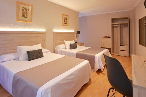 een hotelkamer met 2 bedden en een stoel bij Hotel Villa de Verín in Verín