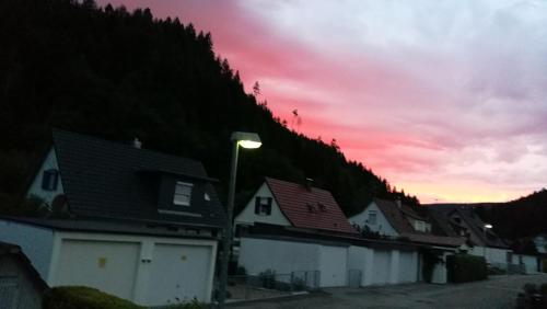 a row of houses with a sunset in the background at Ferienwohnung Adelsberg in Alpirsbach