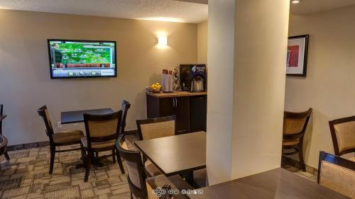 a restaurant with a bar with a television on the wall at Days Inn by Wyndham Calgary Northwest in Calgary