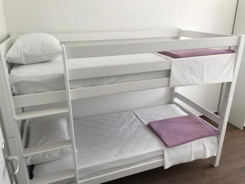 a bunk bed with white bunk beds in a room at Apartments Kuk in Šilo