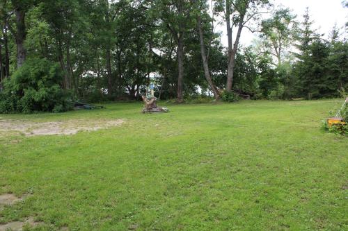 a grassy field with a statue in a park at Mazurska Chata Czepiela in Langendorf