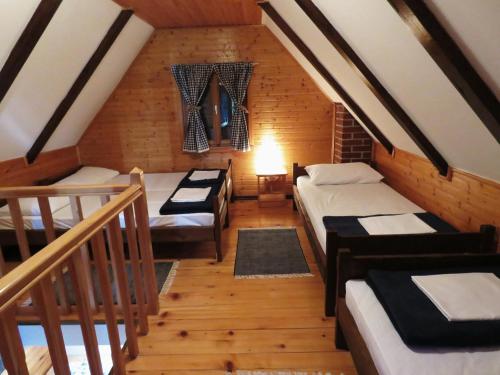 a attic room with four beds and a staircase at Guesthouse Stefanac in Otočac