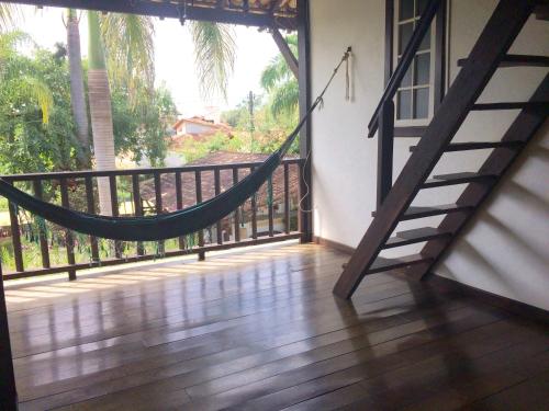 a room with a hammock on a balcony at Atobá Villas in Paraty