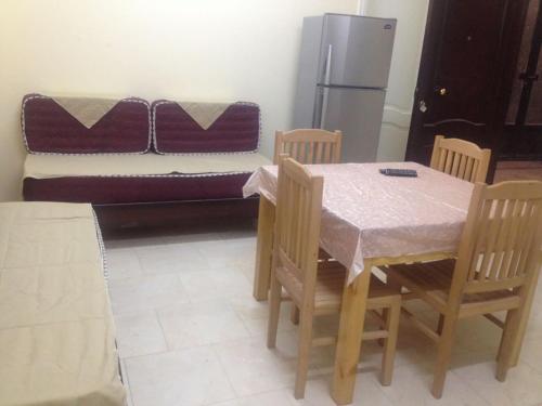 a dining room with a table and chairs and a couch at Happy Days in Hurghada