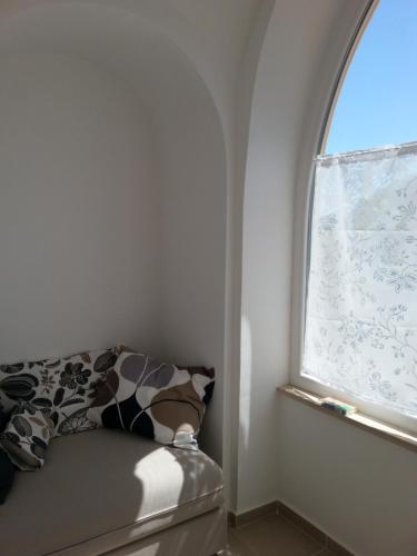 a room with a window with a couch and a pillow at Il Covo delle Civette in Vietri sul Mare