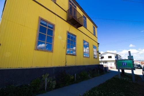 a yellow building with windows on the side of it at Yendegaia House in Porvenir