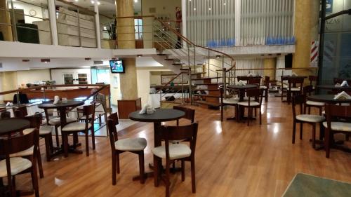 a restaurant with tables and chairs and a staircase at Hotel Cuatro Plazas in Casilda