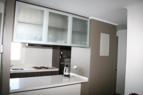 a kitchen with white cabinets and a counter top at Condominio Laguna del Mar in La Serena