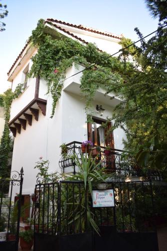 a white house with a plant in front of it at Pension Felippe in Pythagoreio