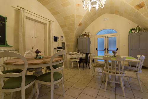 a kitchen and dining room with a table and chairs at Masseria Sorani in Manduria