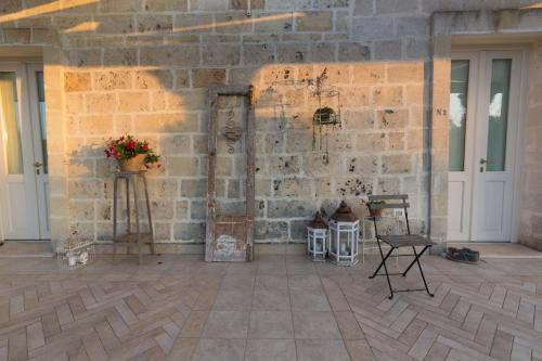 a brick wall with a door and a table and chairs at Masseria Sorani in Manduria