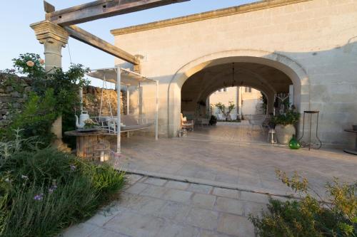 a stone patio with an archway in a building at Masseria Sorani in Manduria