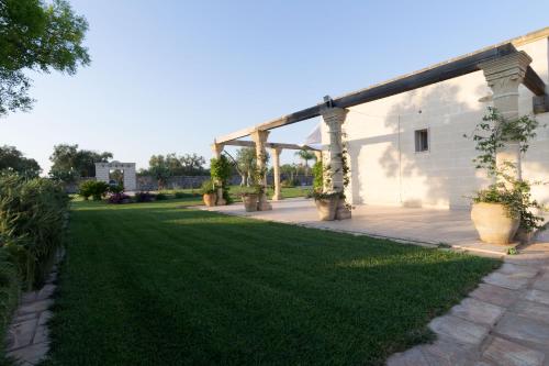 a garden with a pavilion and green grass at Masseria Sorani in Manduria