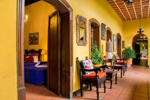 a hallway with chairs and a room with a bed at Hotel Casa Antigua by AHS in Antigua Guatemala
