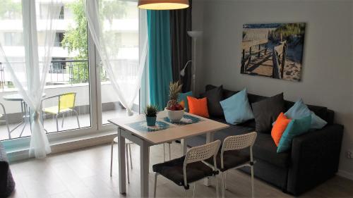 a living room with a couch and a table at APD Apartments - Rezydencja Ustronie Morskie in Ustronie Morskie