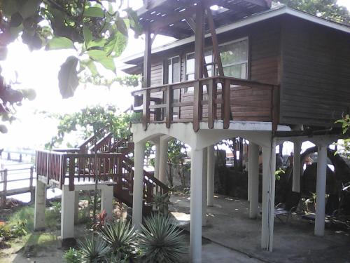 a wooden house with a porch and a balcony at Fosters West Bay Resort in West Bay