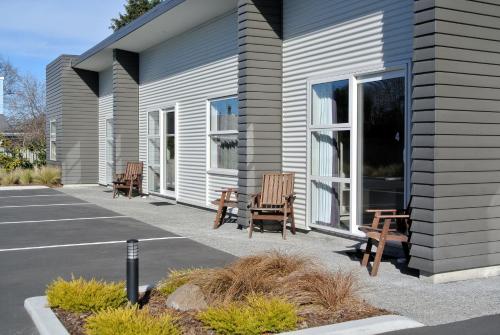 a group of chairs sitting outside of a building at Oxford Village Motels in Oxford