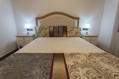a bedroom with a large bed with two night stands at Cañete Medica House in Almodóvar del Río