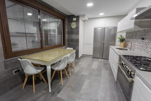 a kitchen with a table and chairs and a stove at Cañete Medica House in Almodóvar del Río
