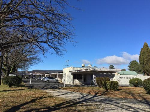 a building with cars parked in a parking lot at Lithgow Valley Motel in Lithgow