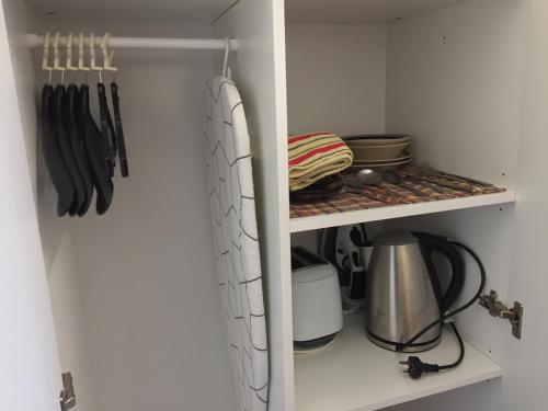 a white cabinet with utensils on a shelf at Lithgow Valley Motel in Lithgow