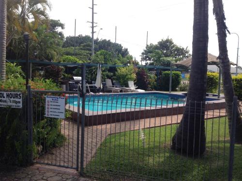 a fence with a sign in front of a swimming pool at Ayr Max Motel in Ayr