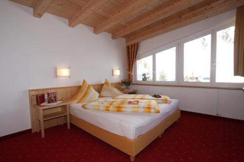 a bedroom with a bed in a room with windows at Gampeler Hof in Galtür