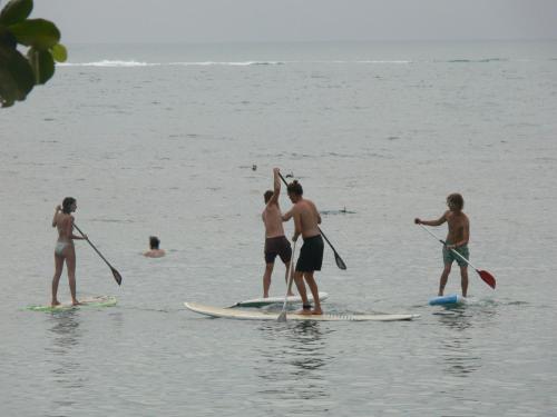 a group of people standing on surfboards in the water at Ibiza Bungalows in Haad Yao