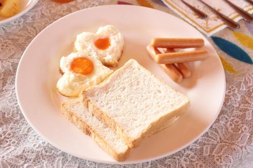 een bord ontbijtproducten met eieren en worst bij Rimlay Park Resort in Phatthalung