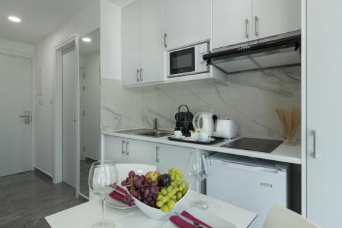 a kitchen with a bowl of fruit on a table at Art & Wine Boutique Hotel in Larnaka