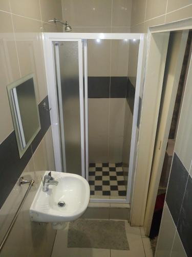 un baño con lavabo y ducha en The Union Hotel, en Durban