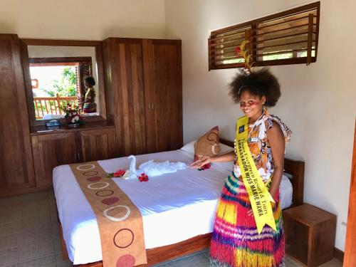 a woman is standing in front of a bed at Tanna Evergreen Resort & Tours in Tanna Island