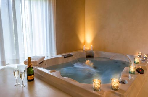 bañera de hidromasaje con velas y botella de vino en Le Silve di Armenzano, en Asís