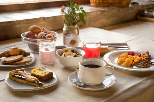 a table with plates of breakfast foods and a cup of coffee at Le Silve di Armenzano in Assisi